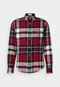 Camisa de manga larga con estampado de cuadros en rojo, negro, gris y blanco, que presenta un cuello con botones y un bolsillo en el pecho.