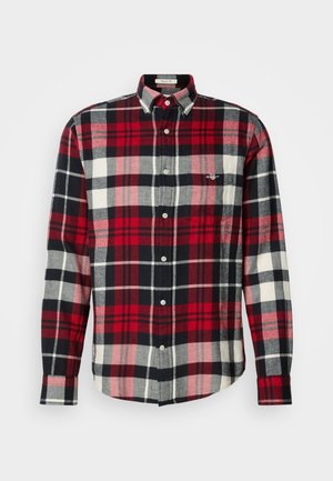 Cămașă cu mânecă lungă și butoniere, cu un model de tartan în culorile roșu, negru, gri și alb, având guler cu buton și un buzunar pe piept.