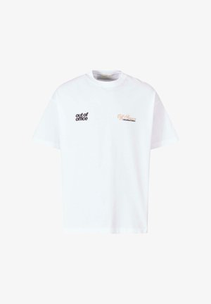 Valge puuvillane T-särk, millel on avar lõige. Vasakul on must "väljas kontorist" tekst ja paremal oranž "Off Season @AnotherCotton" tekst.