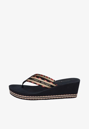 Czarna klapka na koturnie z paskiem z tkaniny w paski z napisem "Tommy Hilfiger" w kolorach czerwonym, beżowym i czarnym.