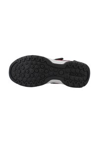 Suola in gomma nera con motivi di battistrada circolari e arcuati. La suola ha un'intermedia bianca ed è parte di un design di sneaker.