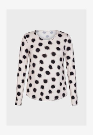 Halenka s dlouhým rukávem z světle béžové látky, zdobená vzorem velkých černých puntíků. Kulatý výstřih a volný střih. Hladká textura.