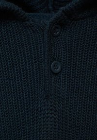 Granatowy sweter z dzianiny o teksturowanym wzorze, z dwoma czarnymi guzikami i zakładanym kołnierzem.