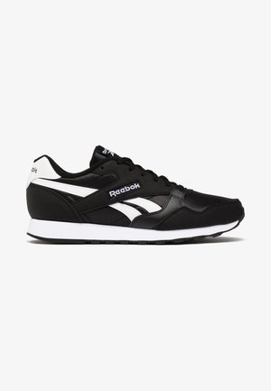 Zapatillas deportivas negras con acentos blancos, fabricadas con materiales sintéticos y textiles, diseño con cordones, con el logo de Reebok en el lateral y en la lengüeta.