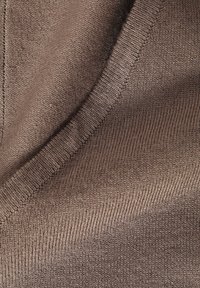 Braunes Strickgewebe mit feiner Textur, das ein V-Ausschnitt-Design und gerippte Kanten aufweist. Weich, leicht und durchgehend einheitliche Farbe.