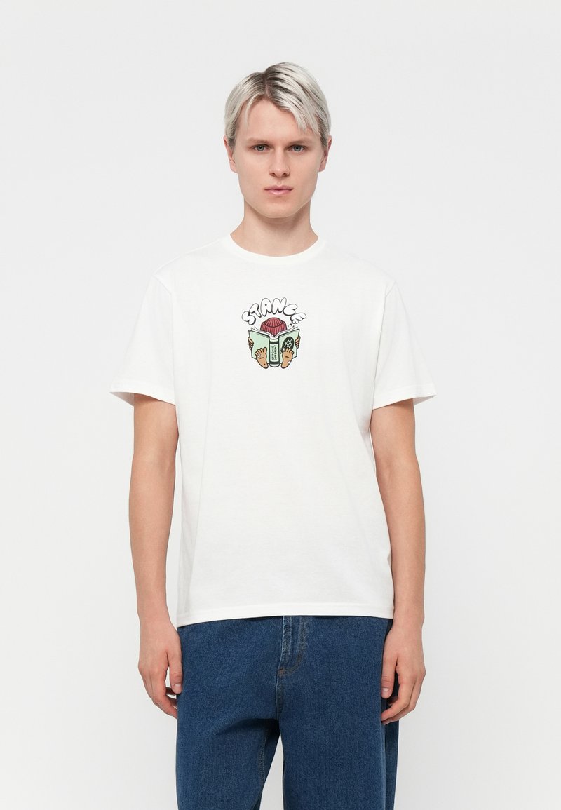 White cotton t-shirt featuring a colorful graphic design on the chest with the word "STRANGE" and various playful motifs. Short sleeves and round neck.