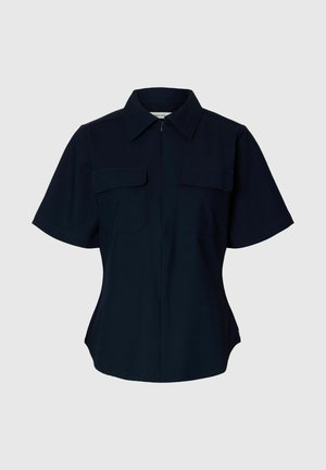 Must must lühikeste varrukatega nööbitav särk terava kraega ja kahe rinnataskuga, liibuva lõikega, esitatud helehallil taustal.