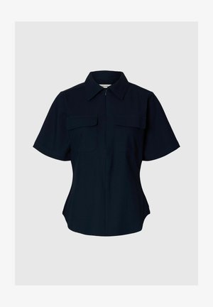 Sort kortærmet skjorte med knapper, spids krave og to brystlommer, skræddersyet pasform, vist på en lysegrå baggrund.