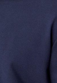 Tissu en coton bleu marine, texture lisse, légèrement extensible, affichant un motif de tricot uniforme sans embellissements ni accessoires visibles.