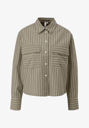 Oliivroheline lühikese lõikega särk, millel on valged vertikaalsed triibud, ning millel on kaks horisontaalset klapptaskut, ninakrae, nööbikäitus ja pikad varrukad.