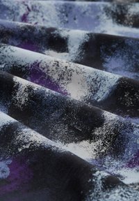 Abstraktní textilie s kombinací černé, fialové a bílé barvy s texturovaným, malířským designem. Materiál vypadá měkce a hladce.