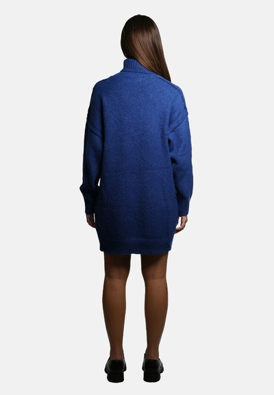 Maglione intrecciato blu oversize con un colletto alto, maniche lunghe e dettagli a coste, che arriva fino a metà coscia. Presenta una silhouette rilassata.