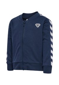 Marint blå zip-up jacka i mjukt material med ribbade manschetter. Har vita chevronränder på ärmarna och en liten broderad logotyp på bröstet.