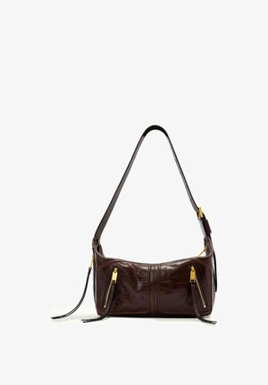 Donkerbruine leren schoudertas met enkele riem en twee verticale gouden ritssluitingen aan de voorkant, liggend op een witte achtergrond.