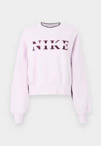 Svetloružový mikin s dlhým rukávom Nike s marhuľovým logom napísaným cez hrudník a rebrovanými manžetami a spodným lemom.