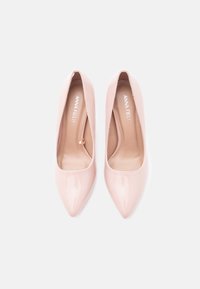 Vaaleanpunaiset patentoidut korkokengät, joissa on kapea kärki ja sileä pinta. Sisäpuolella on Anna Fieldin logolla varustettu merkintä.