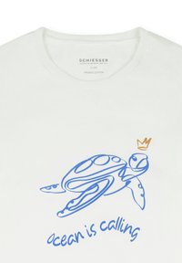 Weißes T-Shirt aus Bio-Baumwolle mit blauem Umriss einer Schildkröte und einer goldenen Krone über dem Text "ocean is calling" in blauer Schreibschrift.