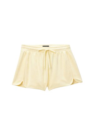 Shorts doux en tissu éponge jaune pâle avec ceinture élastique et cordon réglable, ourlets latéraux arrondis pour un usage décontracté.
