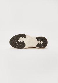 Schuhsohle mit einer langlebigen schwarzen Gummifläche mit strukturierter Oberfläche, weißer Zwischensohle und hexagonalem Profil für besseren Grip.