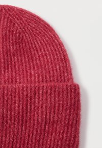 Gorro de punto acanalado rojo, hecho de material suave, con puño doblado y textura suave en toda la tela.