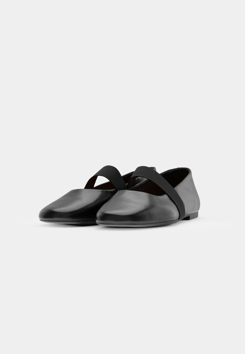 Ballerines noires en cuir avec une finition lisse, dotées d'une sangle élastique noire contrastante sur le coup de pied et d'un design à bout effilé.