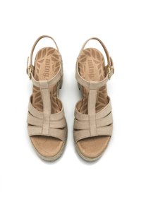 Beige Sandalen mit einer weichen Wildleder-Oberfläche, gekreuzten Riemen und einem Riemen hinten mit einer goldenen Schnalle. Korkplattform und strukturierte Einlegesohle.