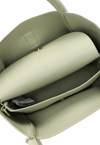 Borsa a mano in pelle verde chiaro con una texture a granuli, dotata di un compartimento centrale e di una tasca con zip, chiusa da un bottone a pressione dorato.