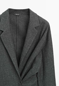 Szary żakiet z mieszanki wełny z klapami, zapinany na jeden guzik, o miękkiej fakturze z delikatnym wzorem.