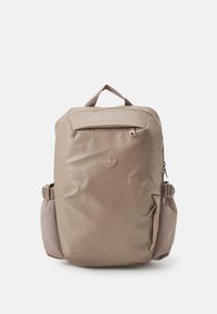 Mochila beige con un acabado brillante, que cuenta con un bolsillo con cremallera en la parte frontal, un bolsillo lateral decorativo y una asa en la parte superior para llevar.
