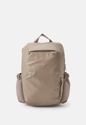 Zaino beige con finitura lucida, dotato di una tasca con zipper frontale, tasca laterale di accento e una maniglia superiore per il trasporto.