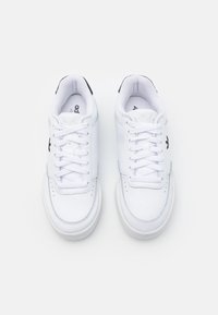 White leather sneakers with a smooth texture, round toe, flat rubber sole, and black accents on the heel and tongue. Laced design.