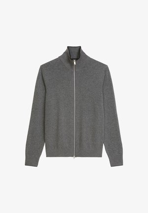 Pull gris en maille avec zip sur le devant et col haut, avec des poignets et un ourlet côtelés. La fermeture éclair à l'avant s'étend sur toute la longueur du pull pour un enfilement facile.