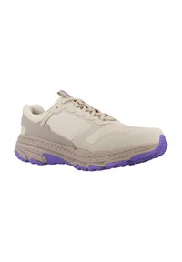 Zapatilla deportiva beige con parte superior de malla, superficies texturizadas, acentos morados en la suela y un diseño estructurado para soporte.