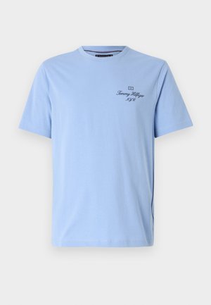 T-shirt en coton bleu clair à manches courtes, avec un col rond et un logo brodé en bleu foncé sur la poitrine.