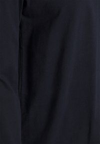 Marineblauwe stof met een zachte textuur, gekenmerkt door een gladde afwerking en minimale zichtbare naden, geschikt voor casual kleding.