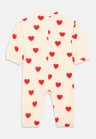 Εκρού βρεφικό φορμάκι με μακριά μανίκια, ελαστικές μανσέτες και κόκκινο σχέδιο καρδιάς σε όλο το ύφασμα.