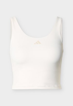 Άσπρο αμάνικο crop top με στρογγυλή λαιμόκοψη και μικρό μπεζ λογότυπο Adidas τοποθετημένο στο κέντρο κοντά στον γιακά.
