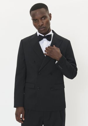Sort dobbeltradet smokingjakke med revers, parret med en hvid skjorte og sort butterfly. Glat stof og skræddersyet pasform.