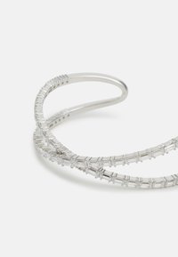 Bracciale in metallo argentato con due bande intrecciate che presentano pietre preziose rettangolari trasparenti, che mette in risalto un design elegante e moderno con una superficie lucida.