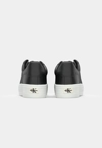 Zwarte leren sneakers met witte zolen en merkopdruk op de hiel. Ontwerp met ronde neus, textuurpanelen en een gladde afwerking.