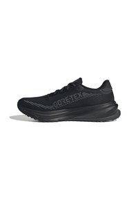 Scarpa sportiva nera con marchio Gore-Tex, suola testurizzata e sovrapposizioni decorate, mostrata dal lato esterno su uno sfondo bianco.