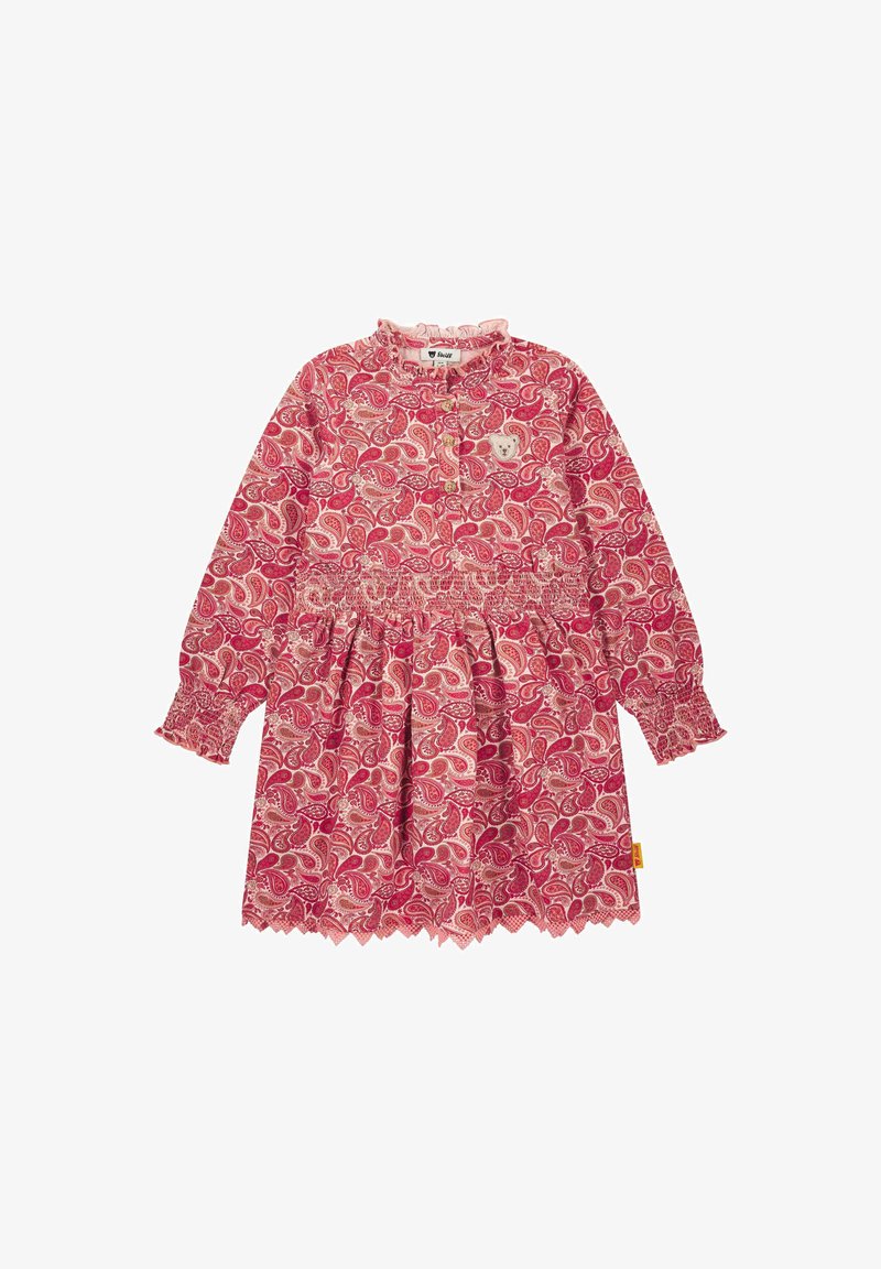 Rotes und pinkes Kleid mit Paisleymuster, langen Ärmeln, gerafftem Taillenbund, Rüschenausschnitt und gekröpftem Saum; verfügt über ein kleines Bärenpatch auf der Brust.