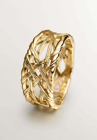 Anillo de metal dorado con un diseño intrincado y entrelazado, con acentos retorcidos y espacios abiertos, que muestra una superficie brillante y texturizada.