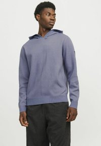 Lila Kapuzenpullover mit lässiger Passform, gerippten Bündchen und tonalem Saum. Der Stoff ist glatt und hat eine doppellagige Kapuze.