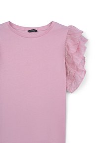 T-shirt rose avec un col rond et une manche en chiffon rose transparent à volants. Tissu doux avec une texture lisse, design minimaliste.