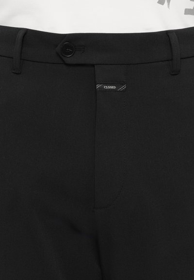 Pantaloni negri dintr-un material neted, cu închidere cu nasture, bucle pentru centură și o etichetă mică "CLOSED" pe talie.