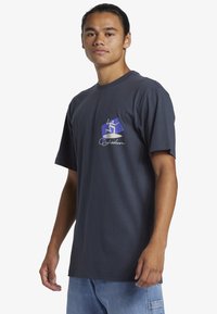 Dark blue T-shirt with short sleeves, featuring a logo in purple and white on the chest area. Made of soft cotton fabric.