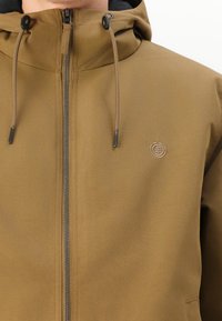 Bruine zip-up jas met capuchon, voorzien van een gladde stoftextuur, verstelbare trekkoorden en een klein logo-detail op de borst.