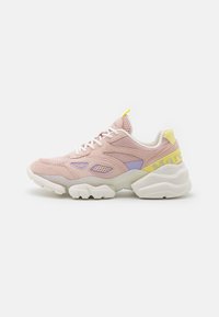 Sneaker chunky in suede rosa e mesh con lacci bianchi, dettagli in viola e giallo, e una spessa suola bianca su uno sfondo bianco.