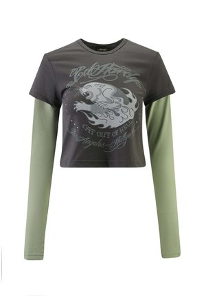 Cropped t-shirt with short, dark gray body and long, light green sleeves. Features front graphic of a panther with flames and text.